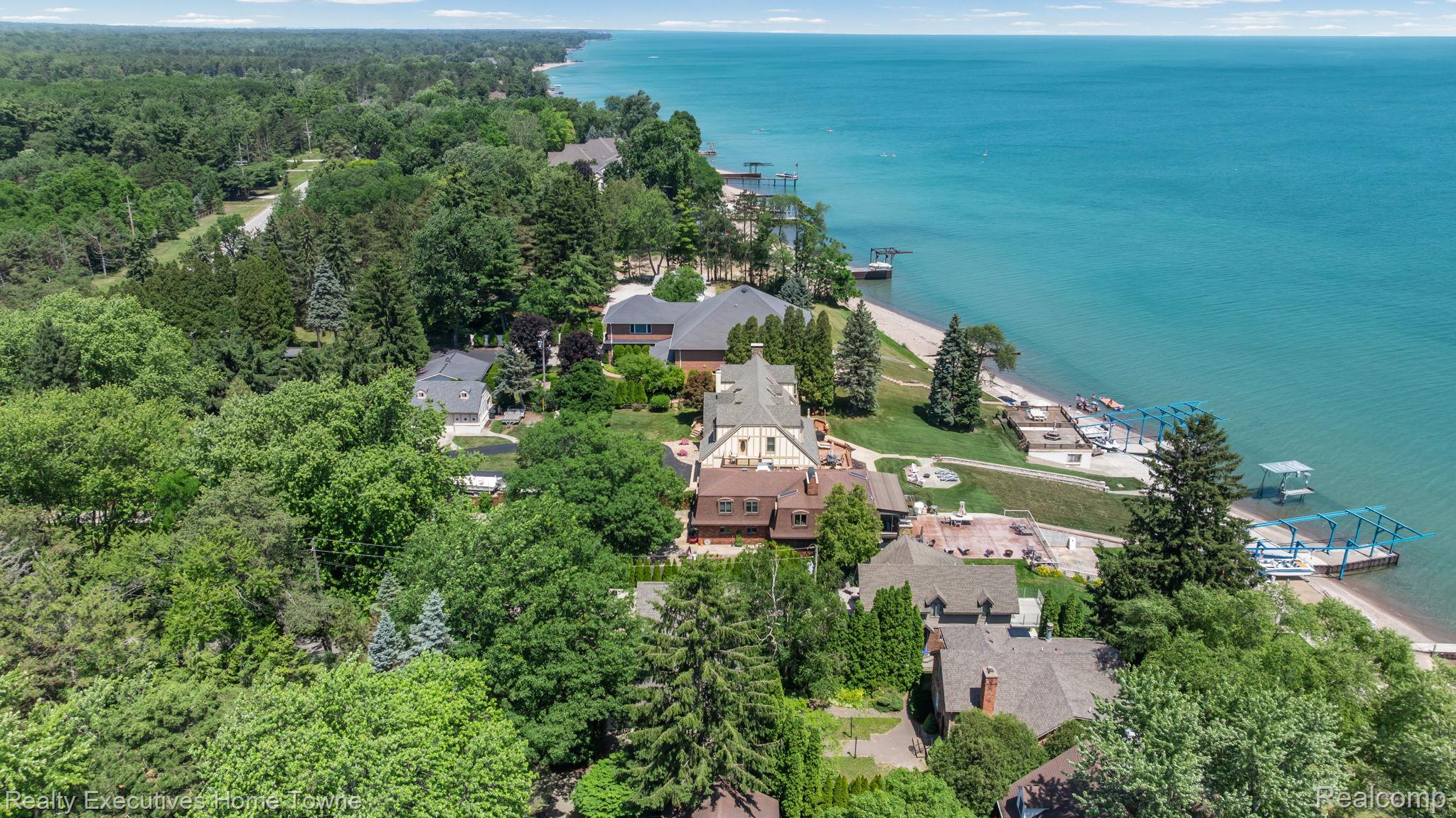8308 Lakeshore Road Fort Gratiot, MI 48059 - Photo 27 of 79 Coastal property featuring a private beach, multiple boat docks, a multi-level dwelling, and mature landscaping