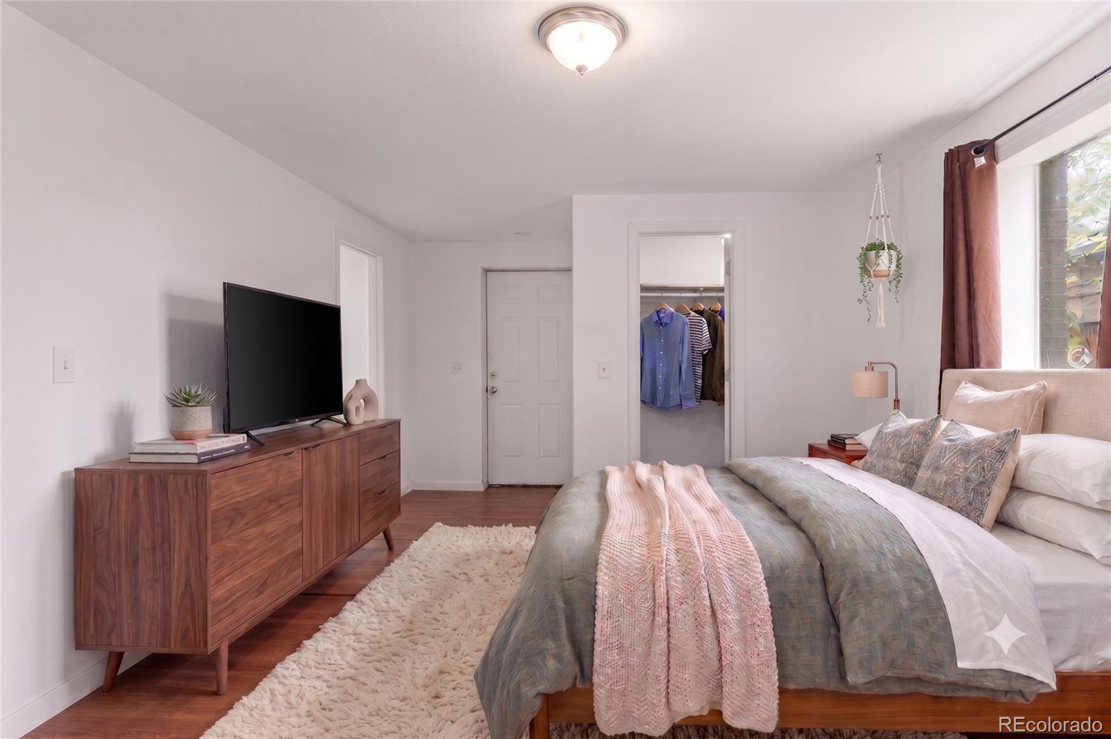 7010 West 44th Avenue Wheat Ridge, CO 80033 - Photo 14 of 31 a bedroom with a bed and a flat screen tv