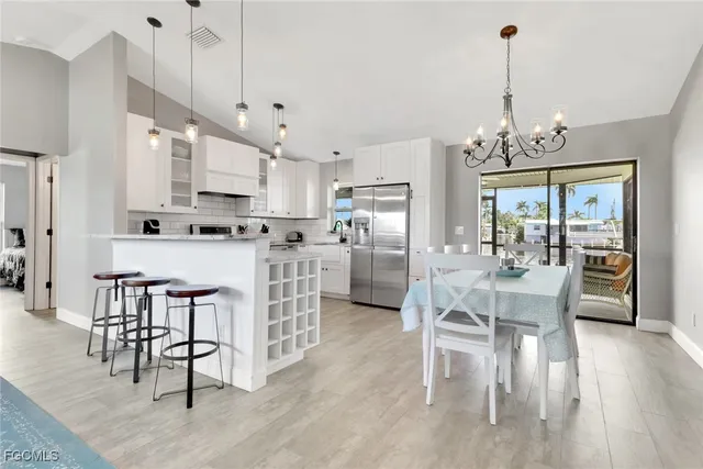 a view of a dining room and livingroom with furniture wooden floor a chandelier