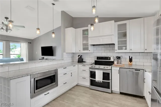 a kitchen with cabinets stainless steel appliances and sink