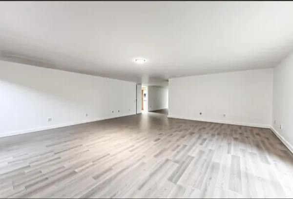 a view of a room with wooden floor and window