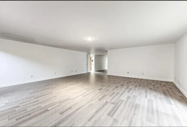 a view of a room with wooden floor and window