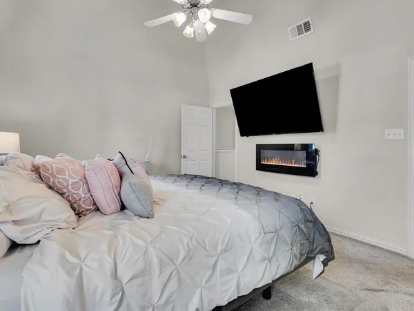 a spacious bedroom with a bed and a chandelier