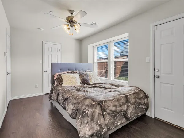 a bed sitting in a bedroom next to a window and a chandelier