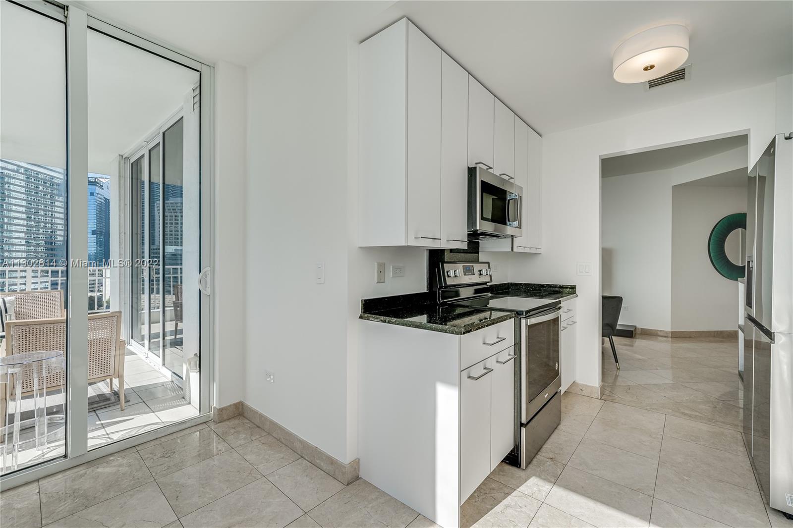 801 Brickell Key Boulevard, Unit 1701 Miami, FL 33131 - Photo 11 of 32 a kitchen with stainless steel appliances granite countertop a stove and a sink