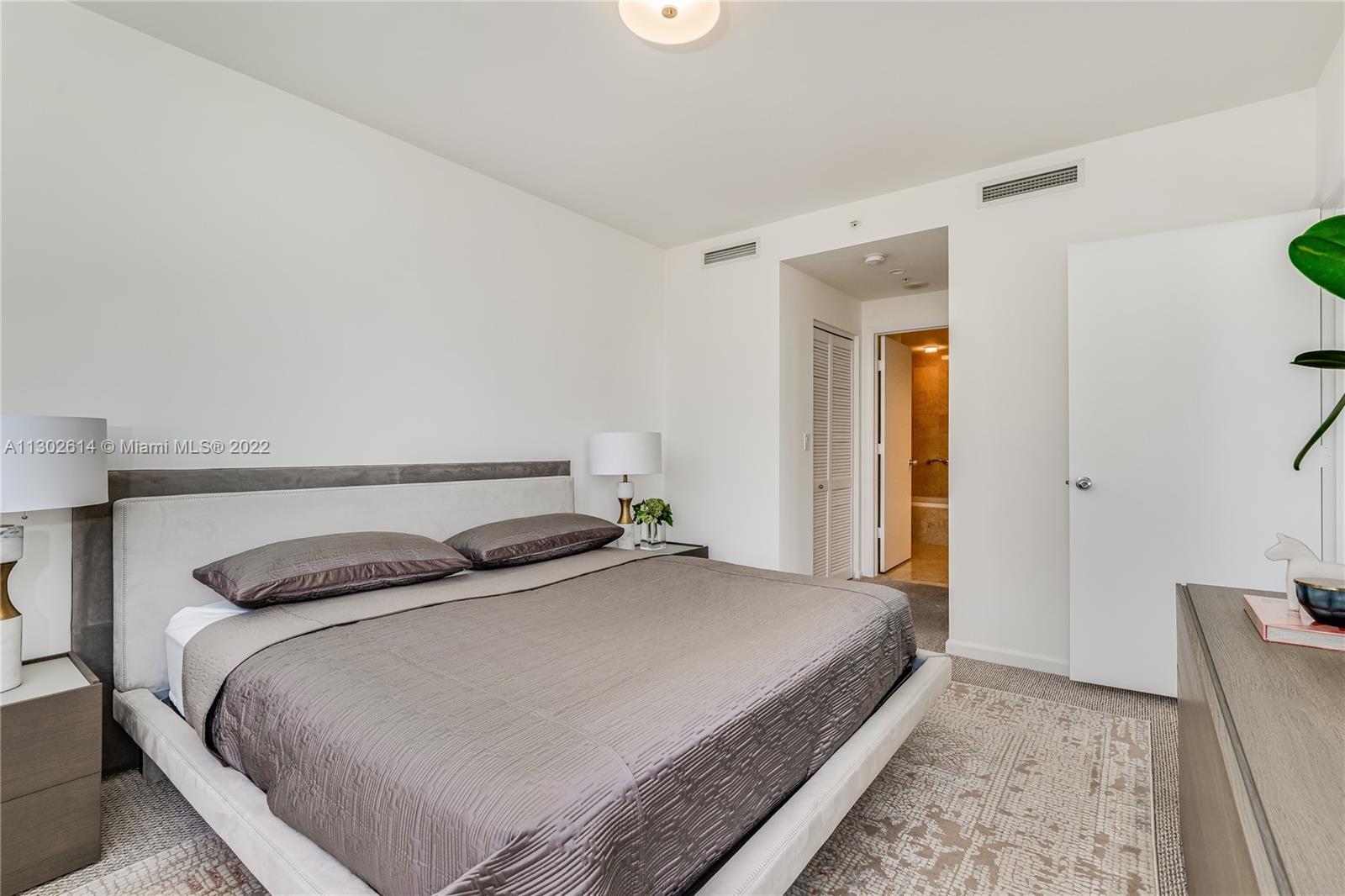 801 Brickell Key Boulevard, Unit 1701 Miami, FL 33131 - Photo 14 of 32 a bedroom with a bed and a window