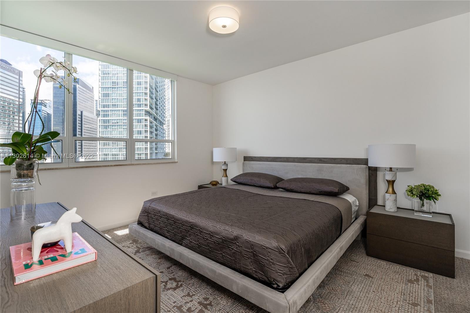 801 Brickell Key Boulevard, Unit 1701 Miami, FL 33131 - Photo 16 of 32 a bedroom with a bed and a potted plant