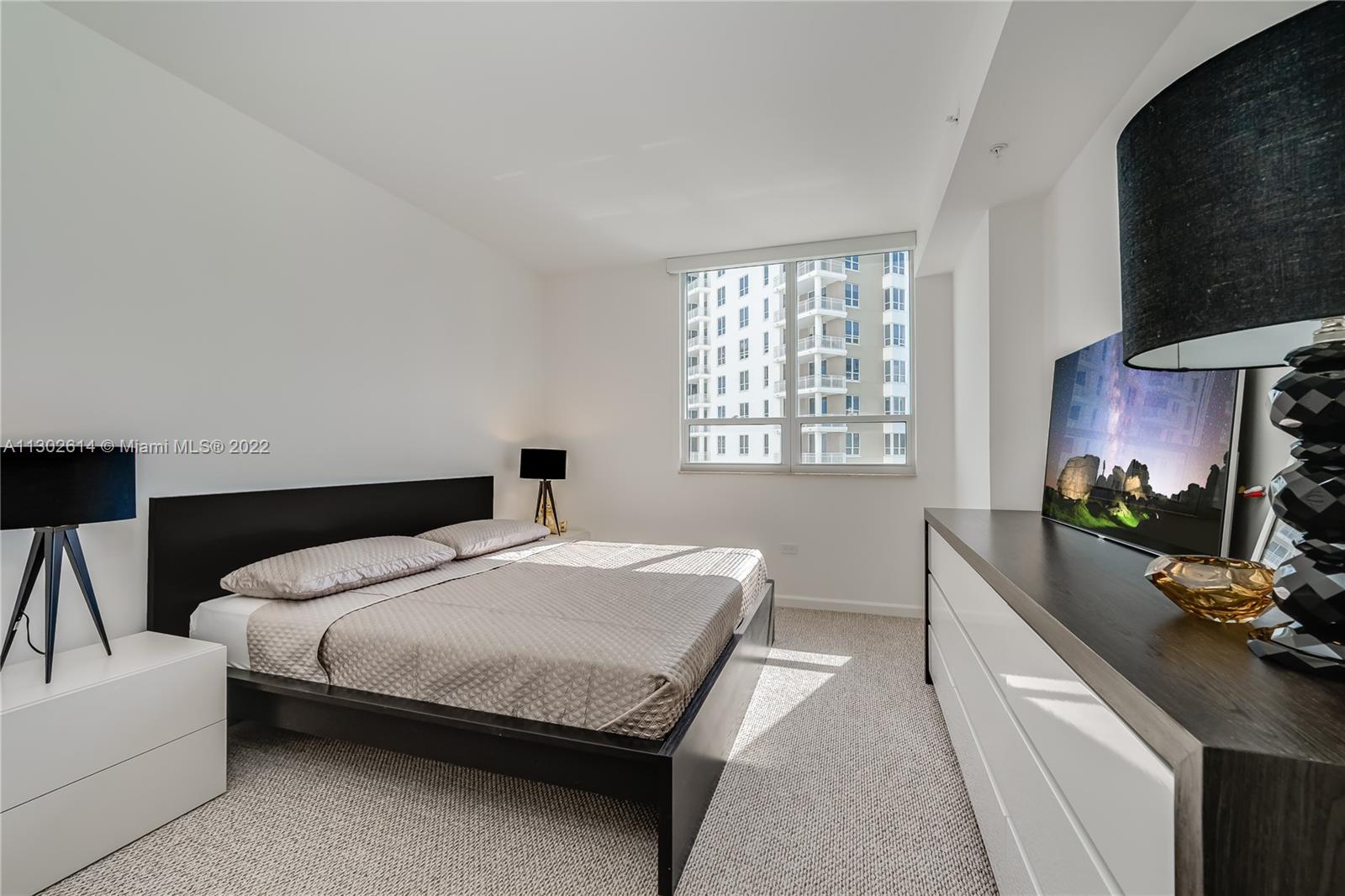 801 Brickell Key Boulevard, Unit 1701 Miami, FL 33131 - Photo 20 of 32 a bedroom with a bed a couch and dresser