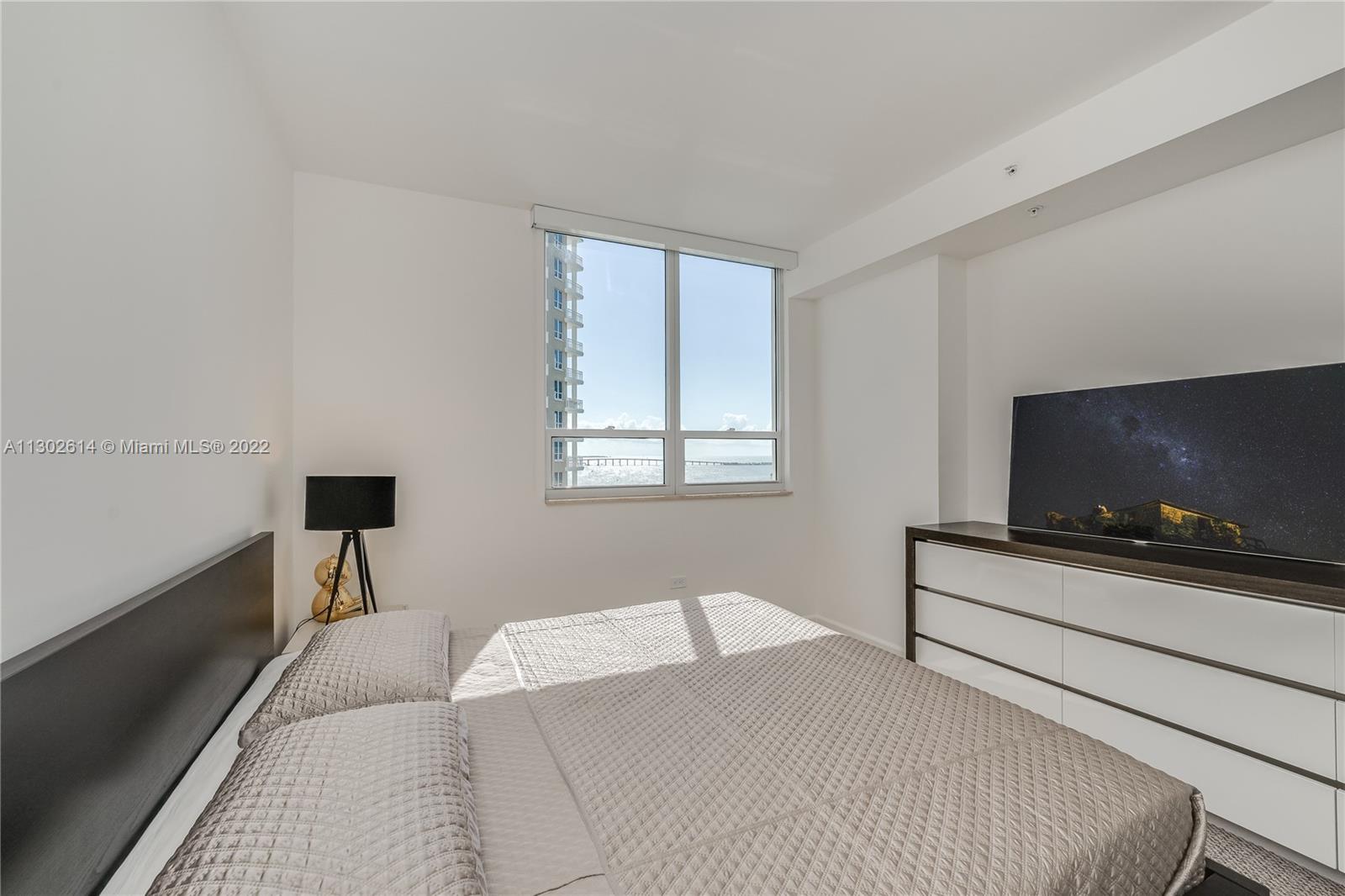 801 Brickell Key Boulevard, Unit 1701 Miami, FL 33131 - Photo 21 of 32 a bedroom with a bed and a flat screen tv