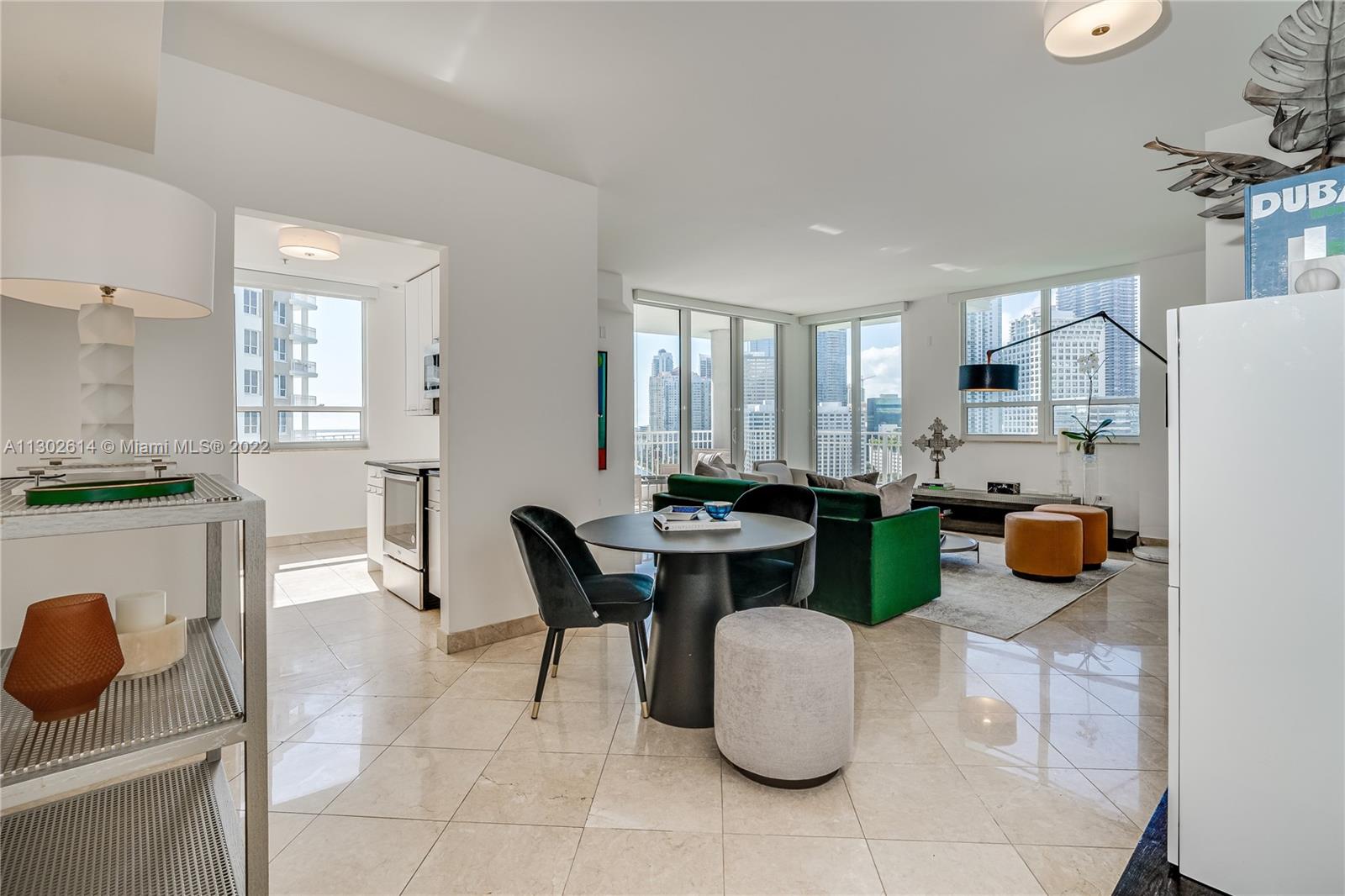 801 Brickell Key Boulevard, Unit 1701 Miami, FL 33131 - Photo 4 of 32 a kitchen with a table chairs and a refrigerator