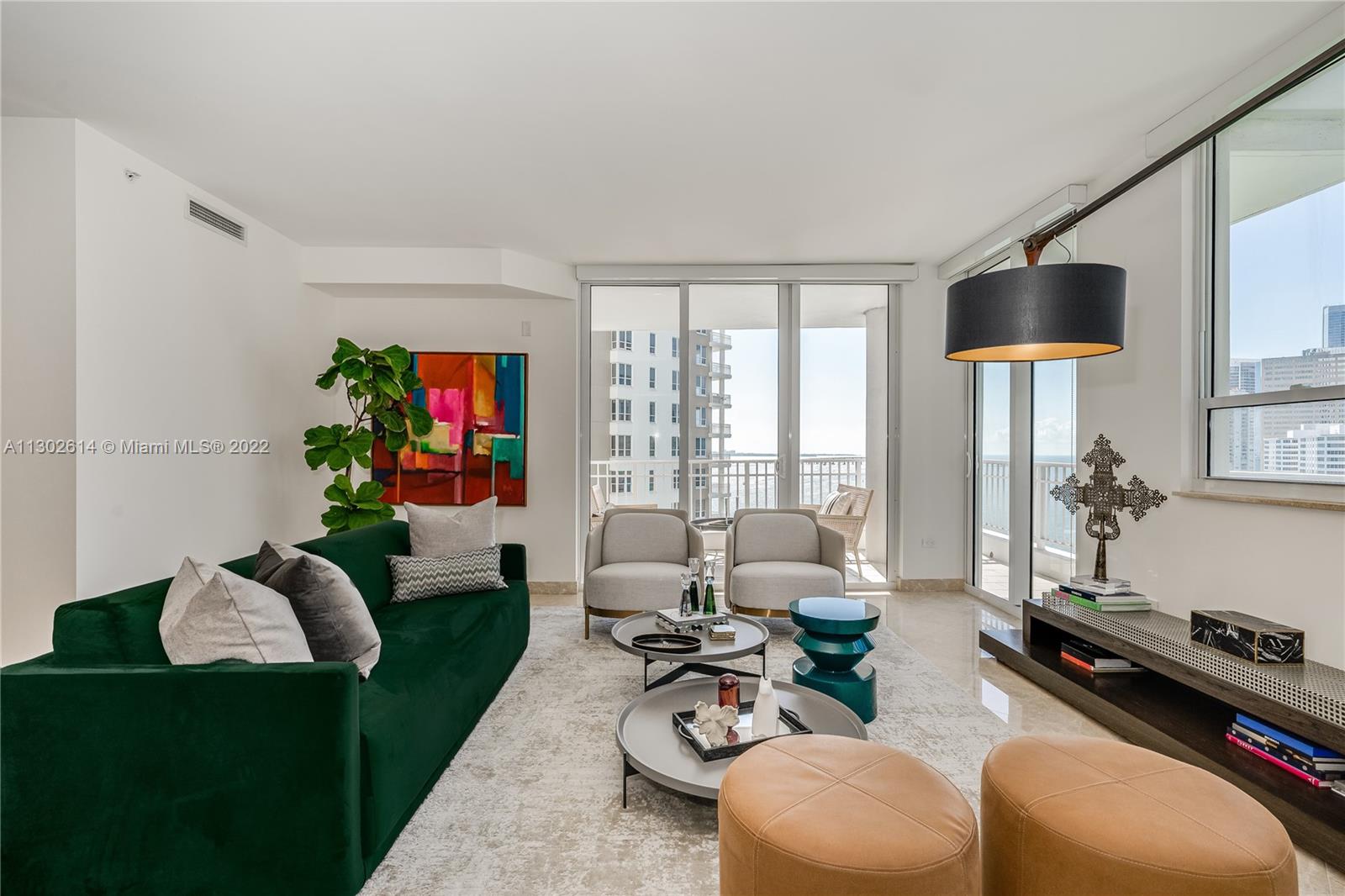 801 Brickell Key Boulevard, Unit 1701 Miami, FL 33131 - Photo 7 of 32 a living room with furniture a flat screen tv and a large window