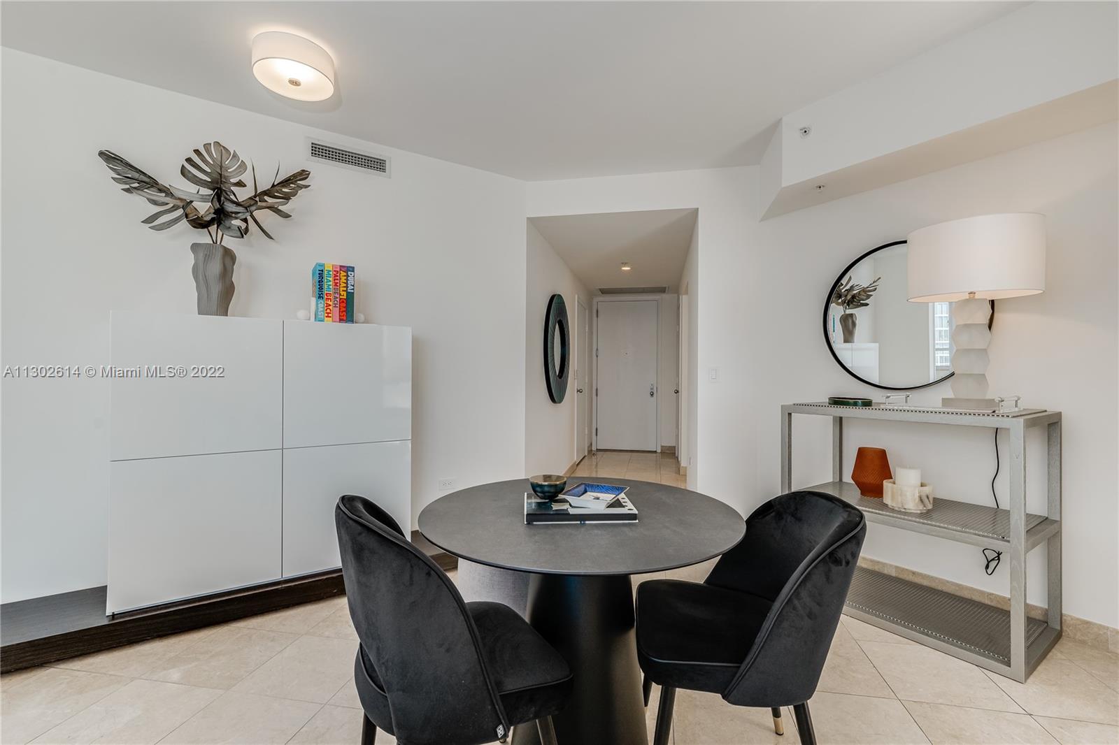 801 Brickell Key Boulevard, Unit 1701 Miami, FL 33131 - Photo 8 of 32 a view of a dining room with furniture and a mirror