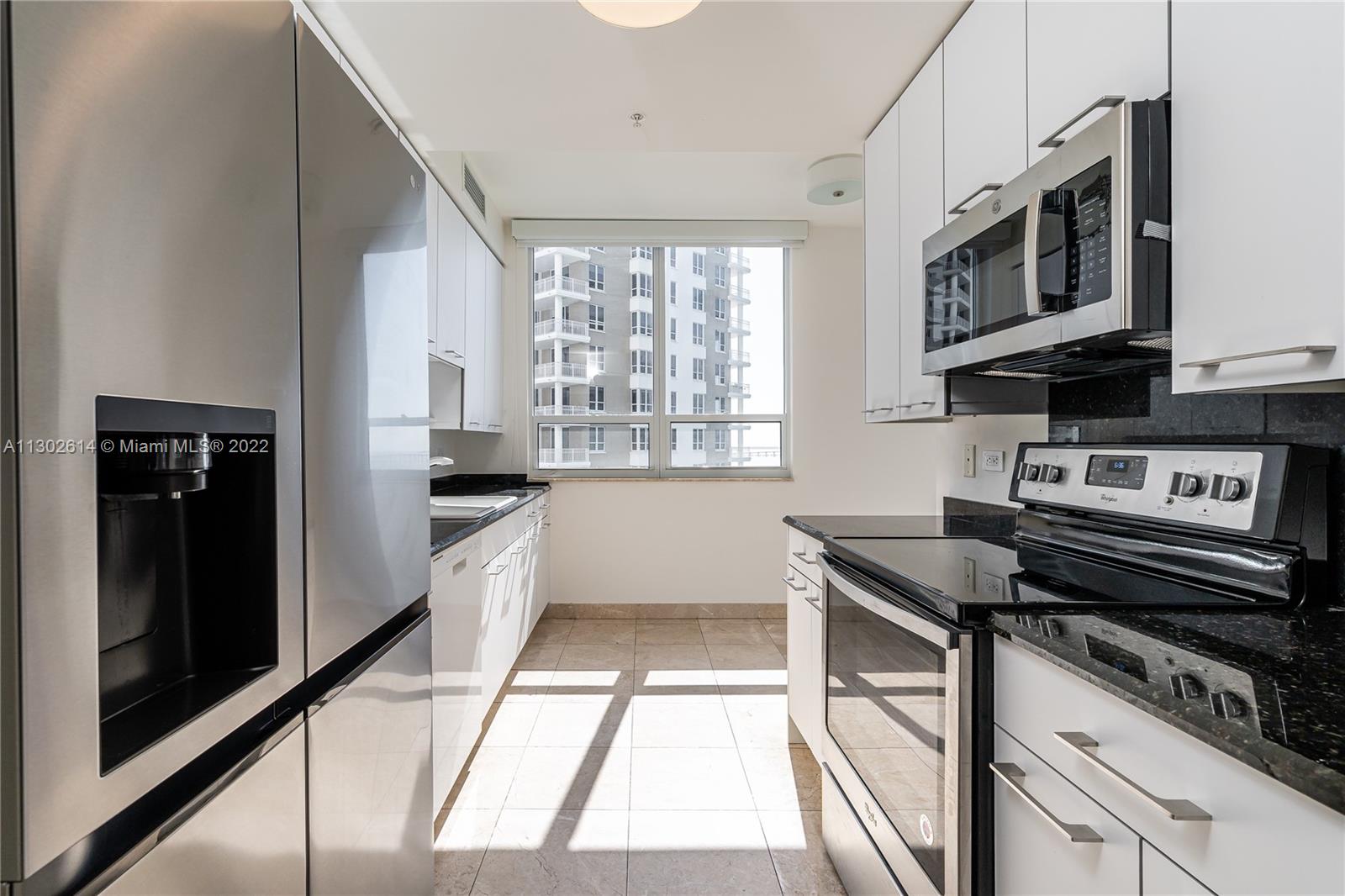 801 Brickell Key Boulevard, Unit 1701 Miami, FL 33131 - Photo 10 of 32 a kitchen with stainless steel appliances granite countertop a stove and a microwave