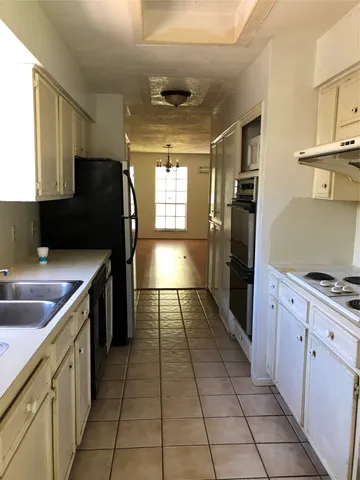 a kitchen with stainless steel appliances granite countertop a refrigerator a sink a stove top oven and cabinets