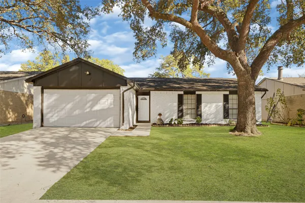 a front view of a house with a garden and yard