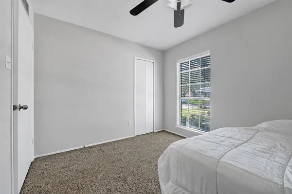 a bedroom with a bed chandelier and window