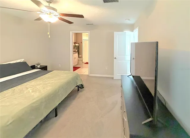 a spacious bedroom with a bed and a chandelier