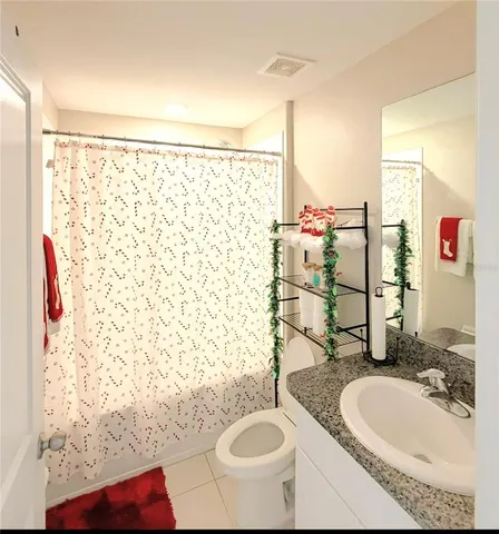 a bathroom with a sink a toilet and shower curtain