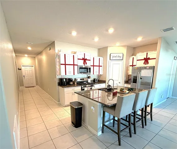 a kitchen with a dining table chairs and white stainless steel appliances