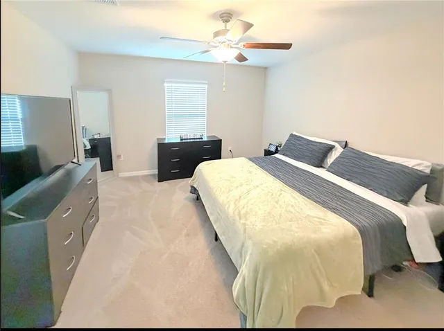 a bed sitting in a bedroom and chandelier