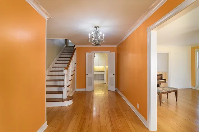 a view of a hallway with wooden floor and stairs
