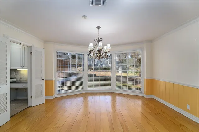 a view of wooden floor and chandelier in living room
