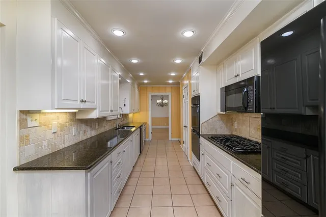 a large kitchen with stainless steel appliances granite countertop a stove and a sink