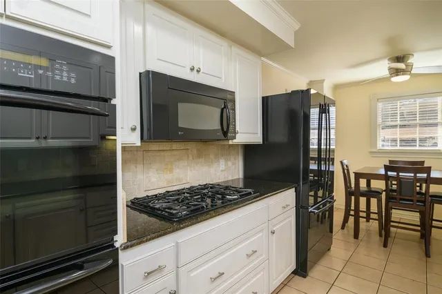 a kitchen with granite countertop a refrigerator stove and microwave