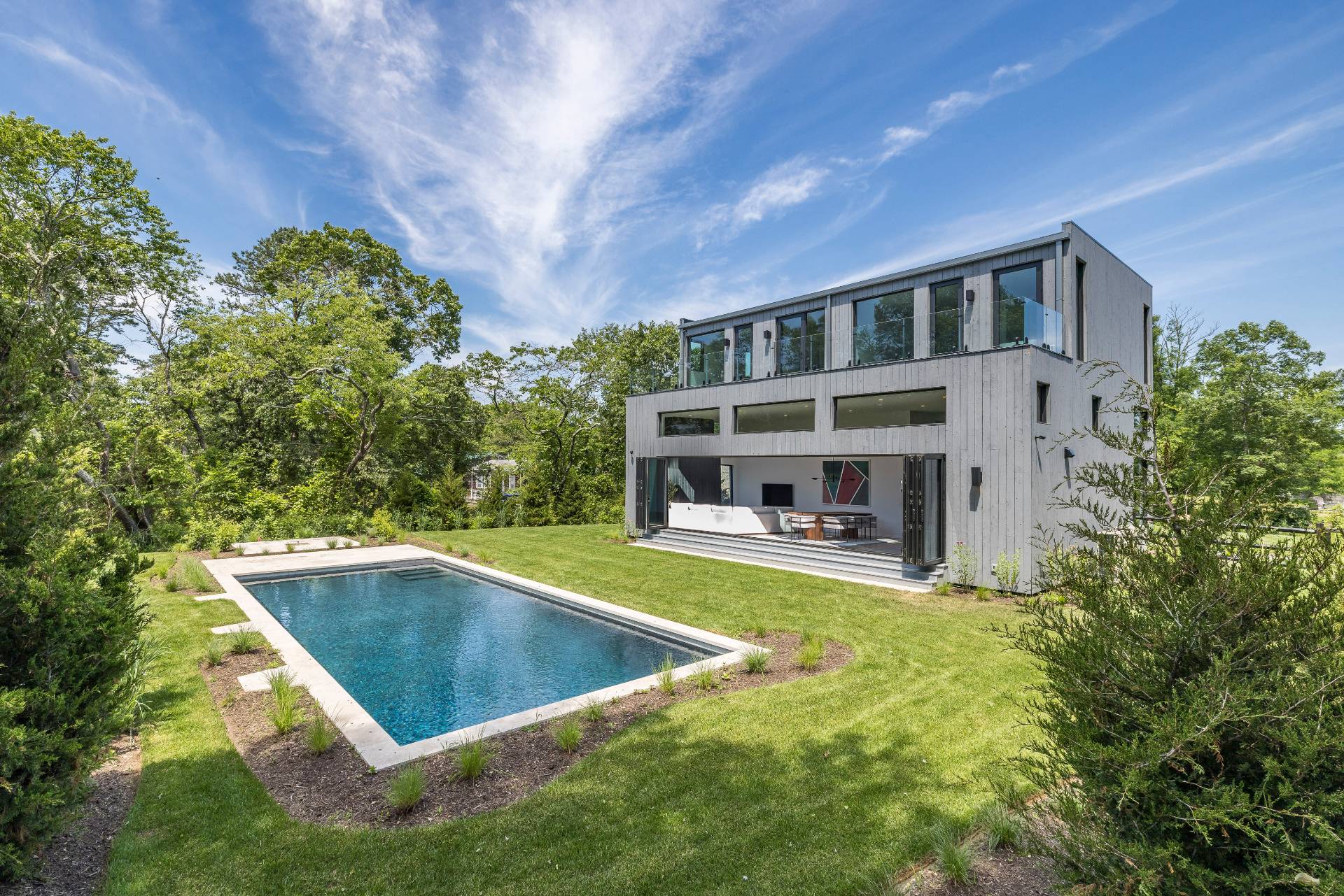 5 Ridge Lane Hampton Bays, NY 11946 - Photo 2 of 38 a view of a house with pool and trees in the background