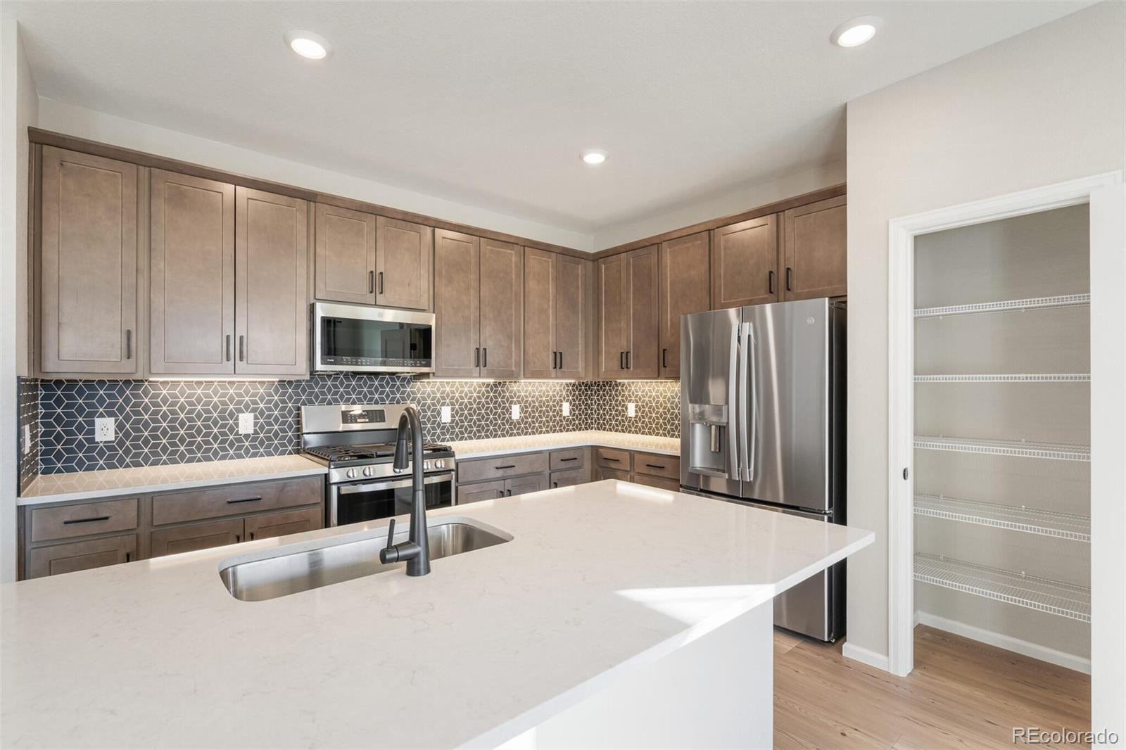 2155 Farmlore Drive Brighton, CO 80601 - Photo 17 of 41 a kitchen with stainless steel appliances a microwave a sink and a refrigerator