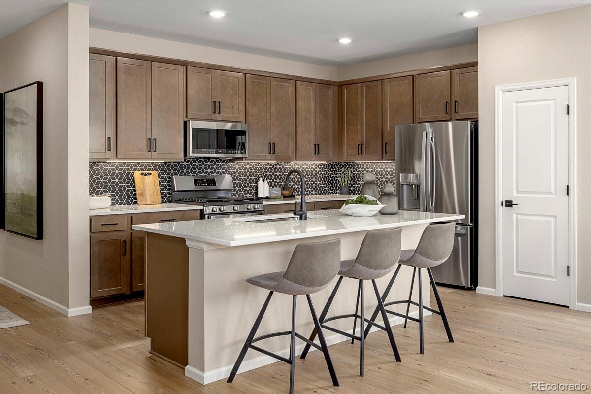 2155 Farmlore Drive Brighton, CO 80601 - Photo 6 of 41 a kitchen with stainless steel appliances granite countertop a stove a sink a microwave a refrigerator and white cabinets with wooden floor