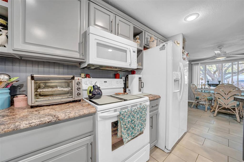 7353 Banner Street New Port Richey, FL 34653 - Photo 11 of 49 a kitchen with stainless steel appliances granite countertop a refrigerator and a stove
