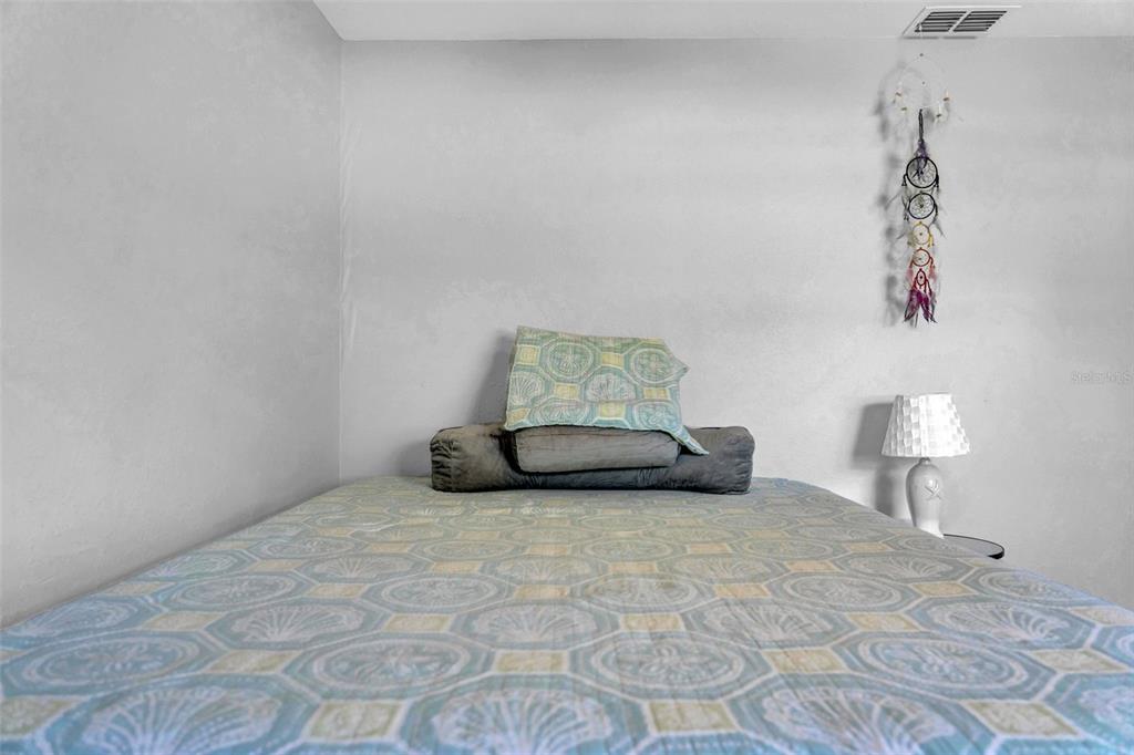 7353 Banner Street New Port Richey, FL 34653 - Photo 30 of 49 a bedroom with a bed and a lamp on the table