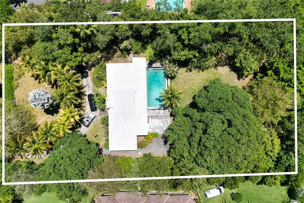 an aerial view of a house and trees all around