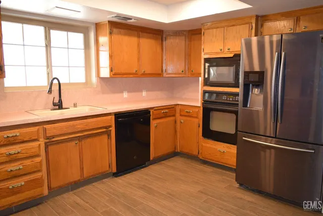 a kitchen with stainless steel appliances granite countertop a refrigerator sink and cabinets