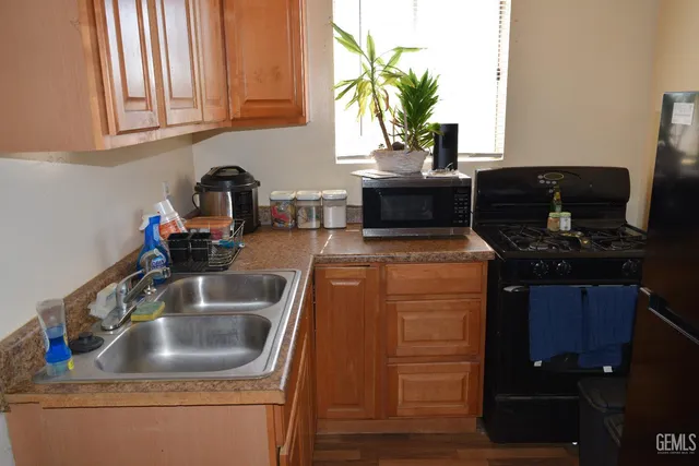 a kitchen with sink a microwave and cabinets