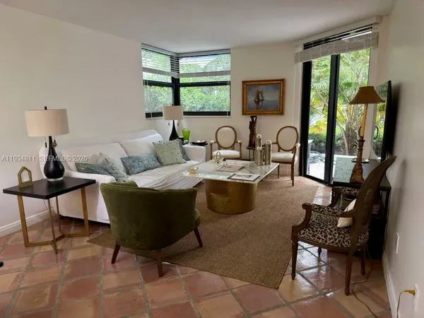 a living room with furniture large window and wooden floor