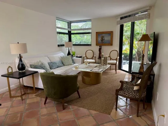 a living room with furniture large window and wooden floor
