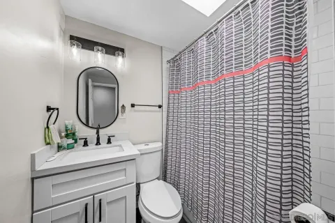 a bathroom with a toilet sink vanity and mirror