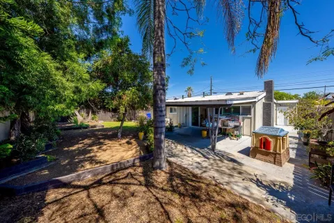 a view of a patio with table and chairs under an umbrella with a tree