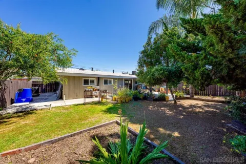 a view of a house with backyard and sitting area