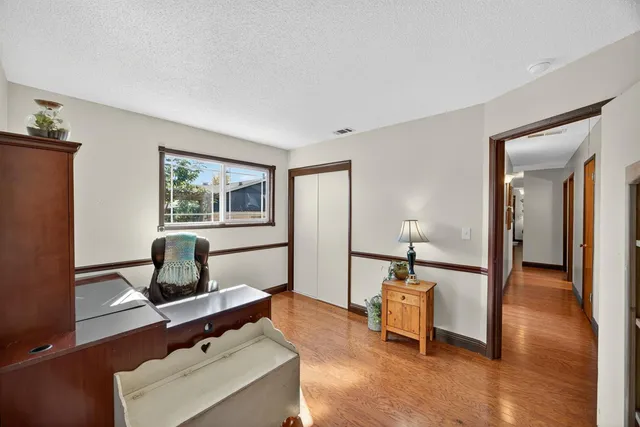a bedroom with a bed a chandelier and a dresser