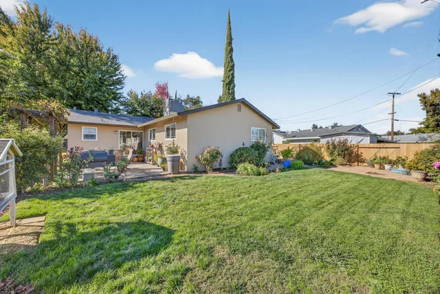 a view of a house with backyard and sitting area