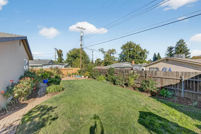 a white house with a small yard and wooden fence