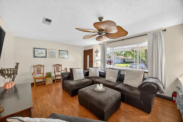 a living room with furniture ceiling fan and a window
