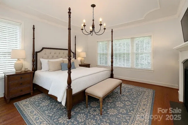 a bedroom with a bed a chandelier and dresser