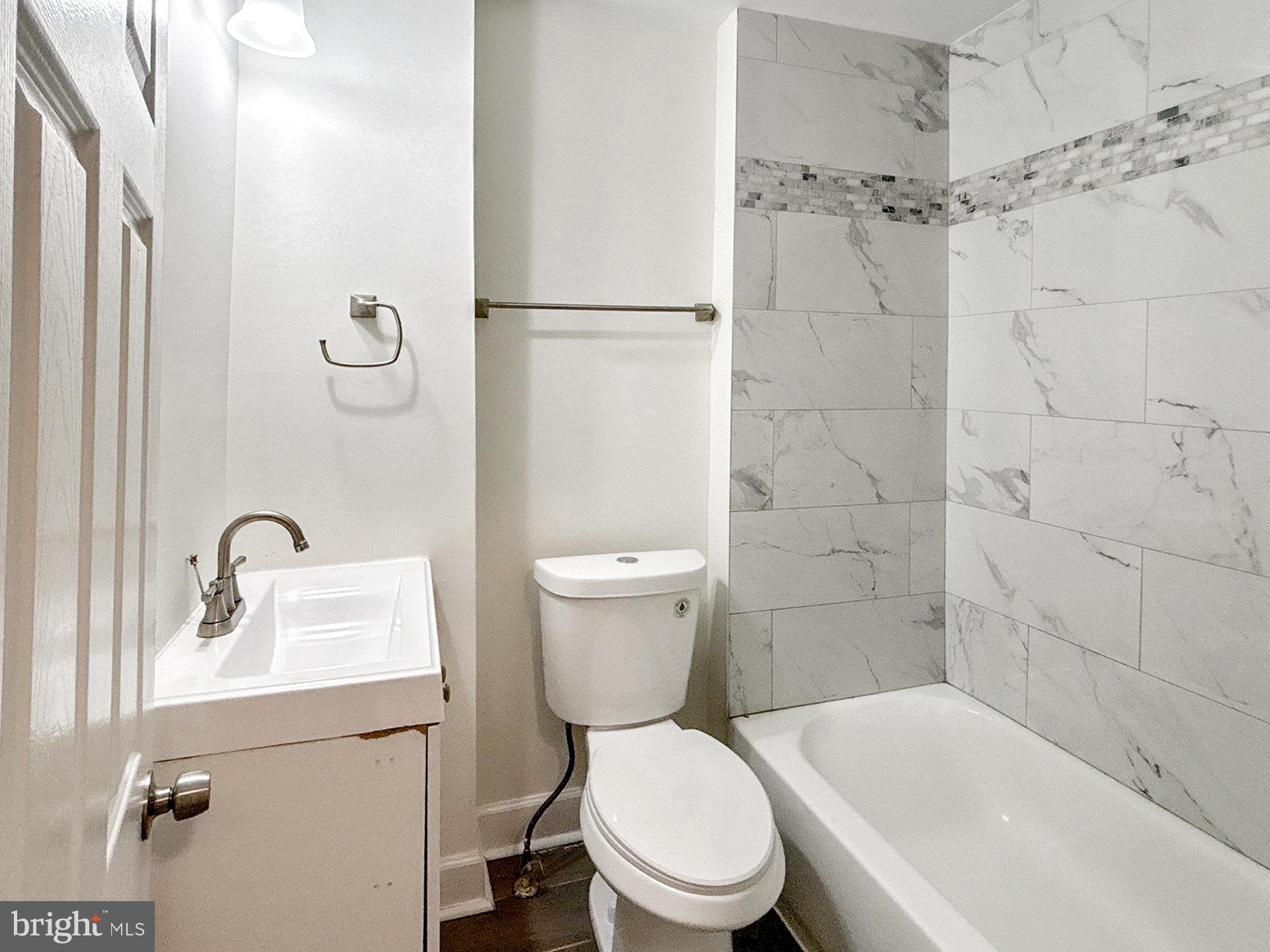 2217 Riggs Avenue Baltimore, MD 21216 - Photo 14 of 26 a white toilet sitting next to a bathroom sink