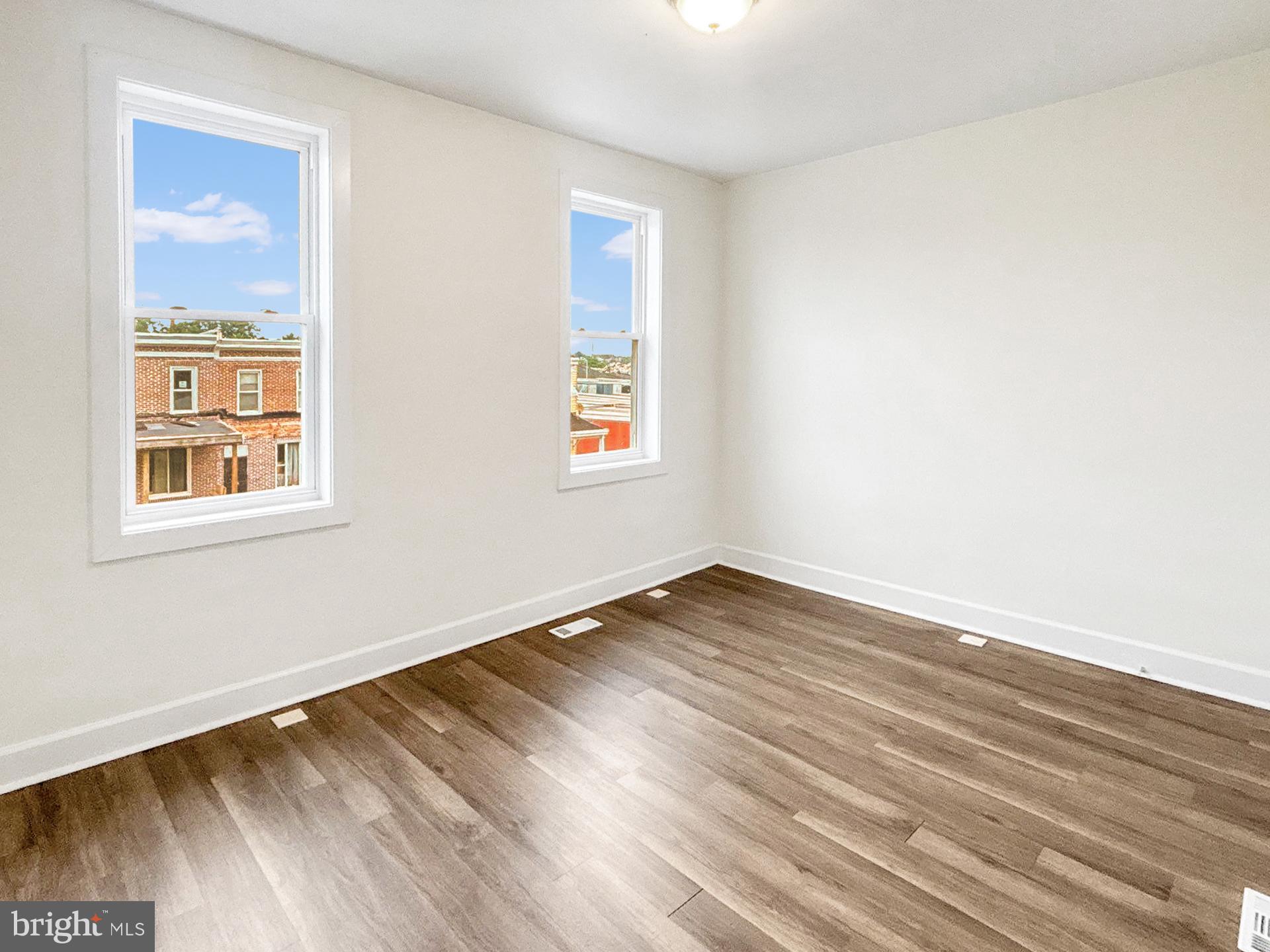 2217 Riggs Avenue Baltimore, MD 21216 - Photo 16 of 26 a view of an empty room with wooden floor and a window