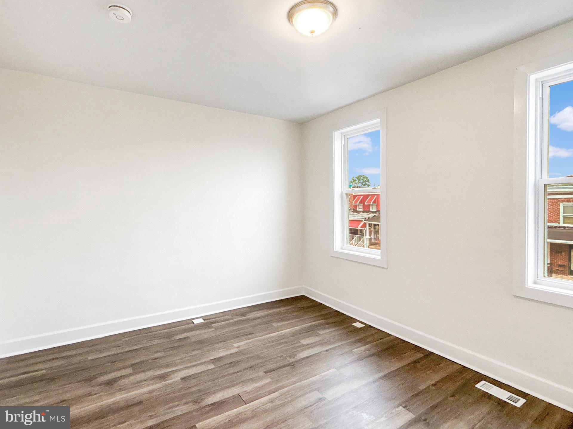 2217 Riggs Avenue Baltimore, MD 21216 - Photo 17 of 26 an empty room with wooden floor and windows