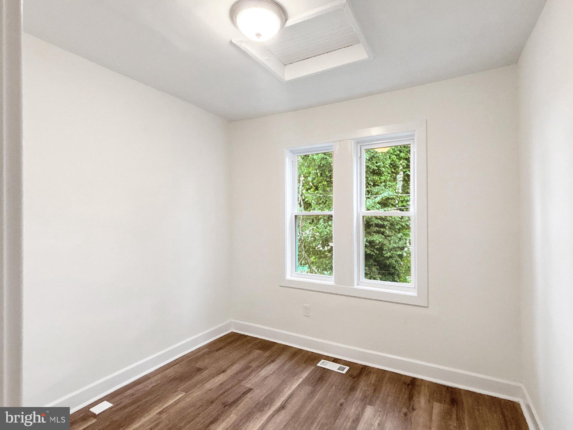 2217 Riggs Avenue Baltimore, MD 21216 - Photo 19 of 26 an empty room with wooden floor and windows